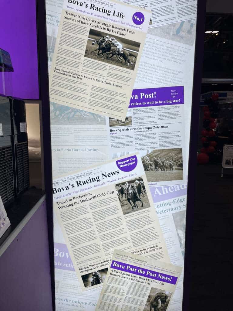 The image shows a display of mock horse racing-themed newspapers at the Bova booth, featuring headlines about Bova’s veterinary products and successes, creatively styled as equestrian racing news.